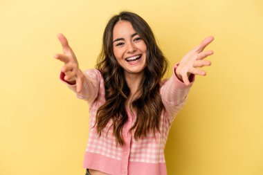 Sarı arka planda izole edilmiş beyaz kadın kameraya sarıldığı için kendini güvende hissediyor..