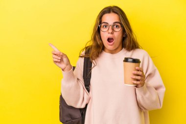 Sarı arka planda kahve tutan Kafkasyalı genç bir bayan...