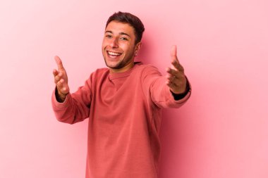 Sarı arka planda dövmeleri olan beyaz bir adam kameraya sarıldığı için kendini güvende hissediyor..