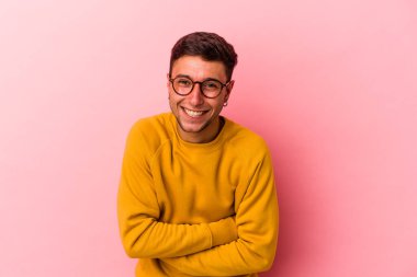 Sarı arka planda izole edilmiş dövmeleri olan beyaz bir adam gülüyor ve eğleniyor..