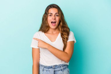 Mavi arka planda izole edilmiş genç beyaz kadın...