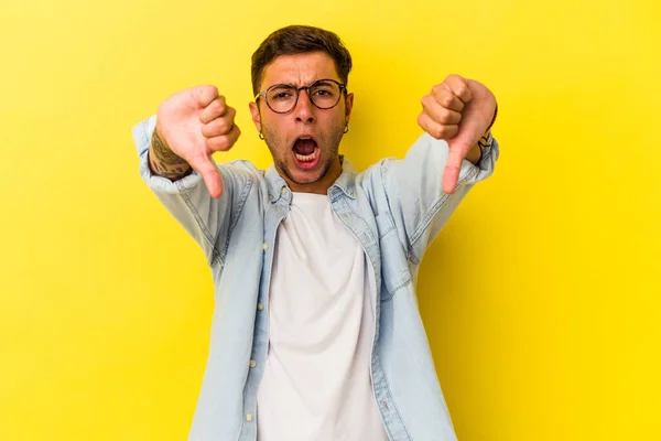 Young Caucasian Man Tattoos Isolated Yellow Background Showing Thumb Expressing — 스톡 사진