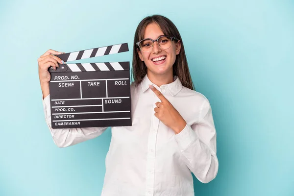Young Caucasian Woman Holding Clapperboard Isolated Blue Background Smiling Pointing — Stock Photo, Image