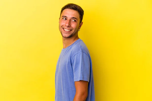 Young Caucasian Man Tattoos Isolated Yellow Background Looks Aside Smiling — Photo