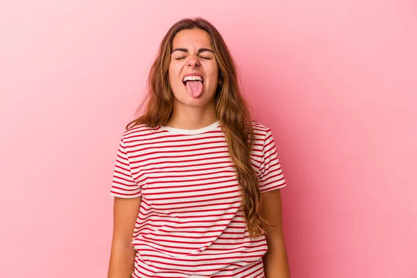 若いですCaucasian女性隔離上のピンクの背景面白いとフレンドリーなステッキングアウト舌 — ストック写真