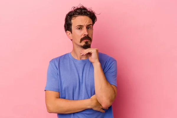 Young Caucasian Man Isolated Pink Background Suspicious Uncertain Examining You — Stock Photo, Image