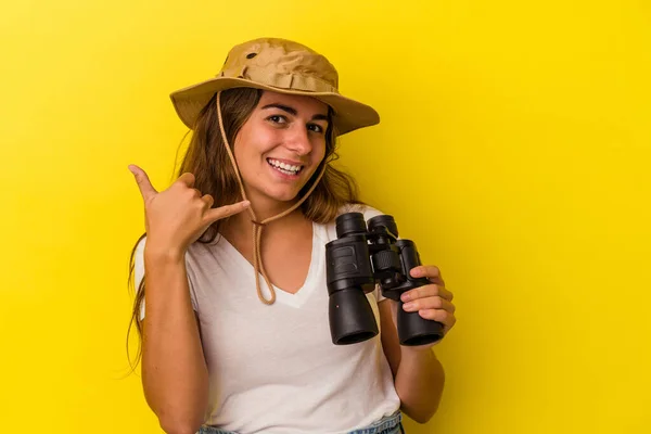 Young Caucasian Woman Holding Binoculars Isolated Yellow Background Showing Mobile — Stock Photo, Image