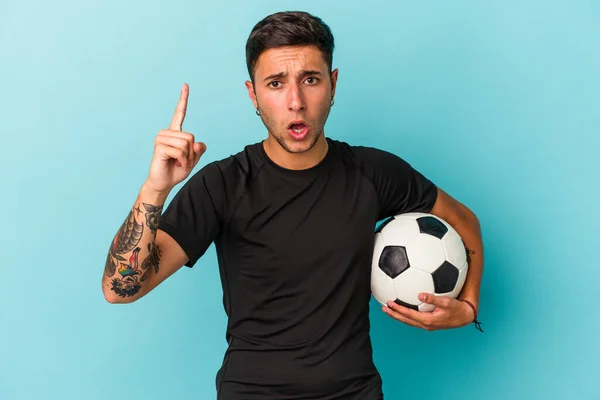 Jovem Jogando Futebol Segurando Uma Bola Isolada Fundo Azul Tendo — Fotografia de Stock