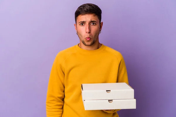 Young Caucasian Man Holding Pizzas Isolated Purple Background Shrugs Shoulders — 스톡 사진