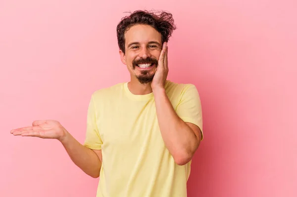 Uomo Caucasico Giovane Isolato Sfondo Rosa Tiene Spazio Copia Una — Foto Stock