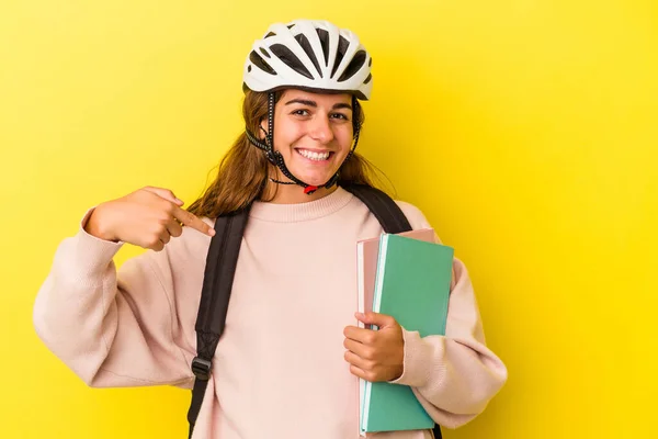 若いです白人学生女性を身に着けています自転車ヘルメット黄色の背景の人に孤立しました手でシャツのコピースペースを指しています 誇りと自信 — ストック写真