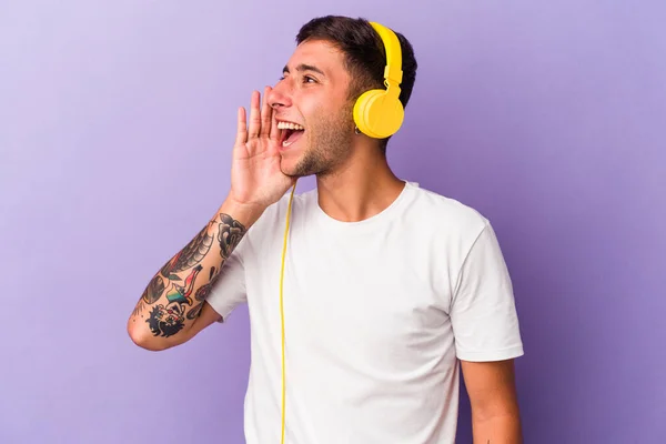 Mladý Běloch Naslouchá Hudbě Izolované Purpurovém Pozadí Křičí Drží Dlaň — Stock fotografie