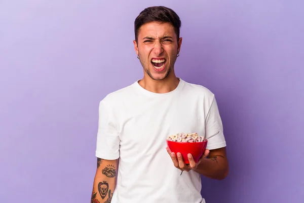 Joven Hombre Caucásico Comiendo Cereales Aislados Sobre Fondo Púrpura Gritando — Foto de Stock