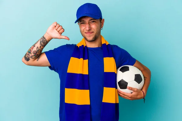 Młody Fan Piłki Nożnej Człowiek Trzyma Piłkę Odizolowany Niebieskim Tle — Zdjęcie stockowe