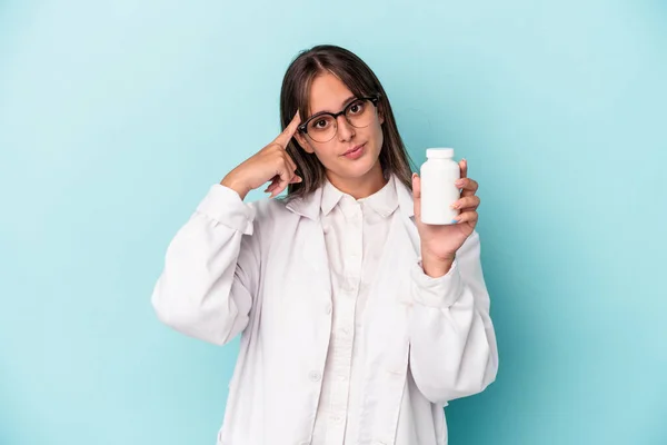 Ung Farmaceut Kvinna Håller Piller Isolerade Blå Bakgrund Pekar Tempel — Stockfoto