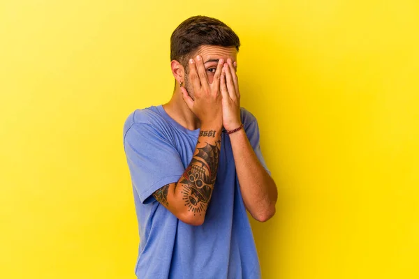 Young Caucasian Man Tattoos Isolated Yellow Background Blink Fingers Frightened —  Fotos de Stock