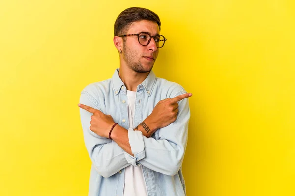 Young Caucasian Man Tattoos Isolated Yellow Background Points Sideways Trying —  Fotos de Stock