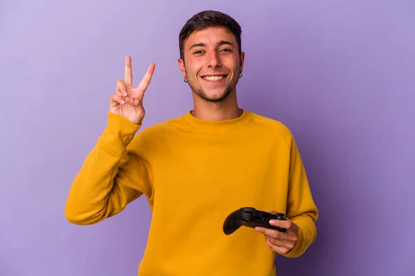 Young Caucasian Man Holding Game Controller Isolated Purple Background Showing —  Fotos de Stock