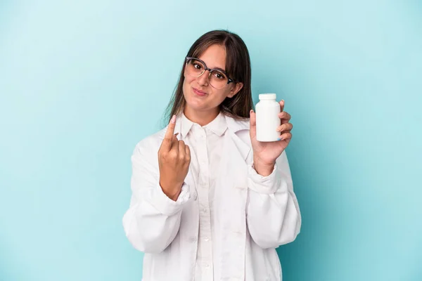 Young Pharmacist Woman Holding Pills Isolated Blue Background Pointing Finger — Stockfoto