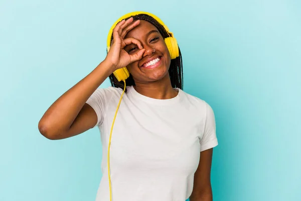 Young African American Woman Listening Music Isolated Blue Background Excited — Stockfoto