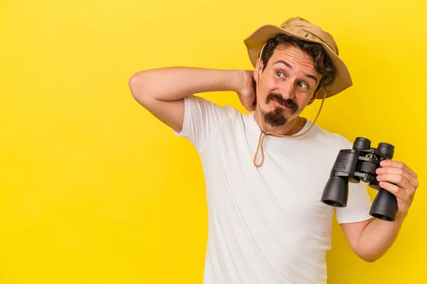 Young Caucasian Man Holding Binoculars Isolated Yellow Background Touching Back — 图库照片