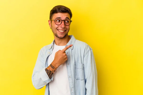 Young Caucasian Man Tattoos Isolated Yellow Background Looks Aside Smiling — Stock Photo, Image