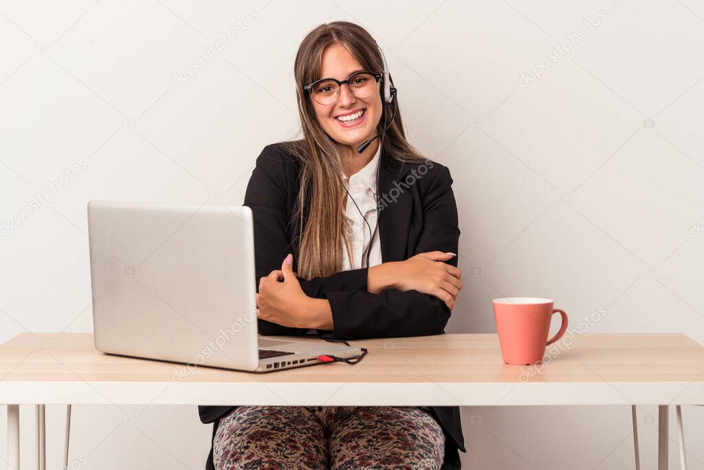 Young caucasian woman doing telecommuting isolated on white background laughing and having fun.