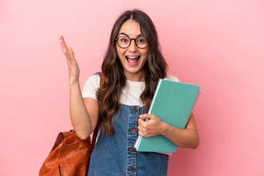 Young caucasian student woman isolated on pink background receiving a pleasant surprise, excited and raising hands.