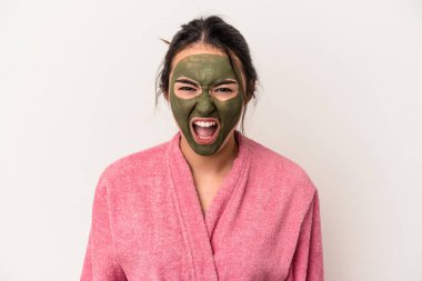 Young caucasian woman wearing a facial mask isolated on white background screaming very angry and aggressive.