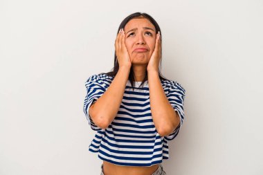 Beyaz arka planda yalnız kalmış, ağlayan ve sızlanan genç Latin bir kadın..