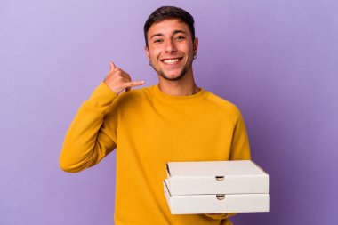 Mor arka planda pizza tutan beyaz bir adam parmakları olan bir cep telefonu hareketi gösteriyor..