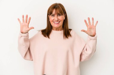 Beyaz arka planda izole edilmiş orta yaşlı beyaz kadın on numarayı elleriyle gösteriyor..
