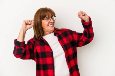 Beyaz arka planda izole edilmiş orta yaşlı beyaz kadın özel bir günü kutluyor, atlıyor ve enerjiyle kollarını kaldırıyor..