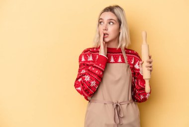 Sarı arka planda izole bir şekilde Noel için kurabiye yapan Kafkasyalı genç fırıncı kadın gizli bir sıcak fren haberinin olduğunu söylüyor.