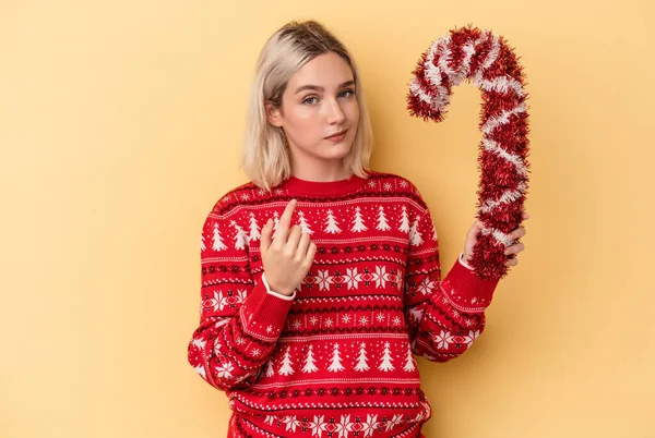 Ung Kaukasisk Kvinna Håller Stora Julpinne Isolerad Gul Bakgrund Pekar — Stockfoto