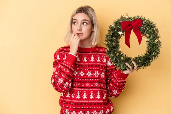Young Caucasian Woman Holding Christmas Wreath Isolated Yellow Background Relaxed —  Fotos de Stock