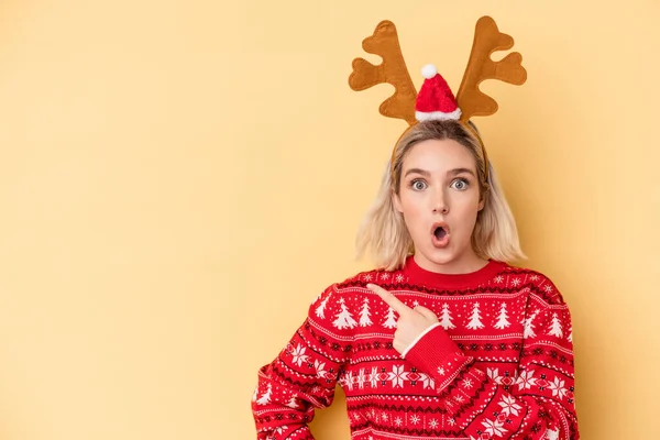 Jovem Caucasiana Vestindo Chapéu Rena Natal Isolado Fundo Amarelo Apontando — Fotografia de Stock