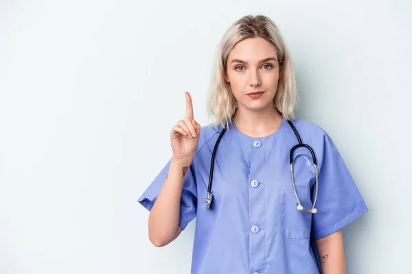 Ung Sjuksköterska Kvinna Isolerad Blå Bakgrund Visar Nummer Ett Med — Stockfoto