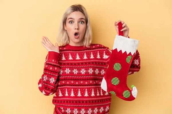 Mladá Běloška Žena Drží Elf Ponožka Izolované Žlutém Pozadí Překvapené — Stock fotografie