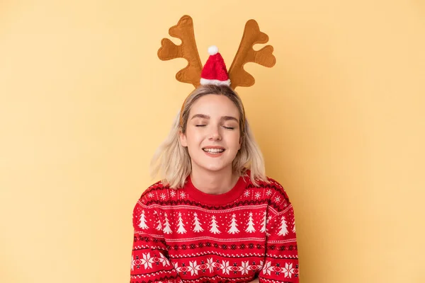 若いです白人女性身に着けていますクリスマストナカイ帽子孤立した黄色の背景笑いと楽しみを持っています — ストック写真
