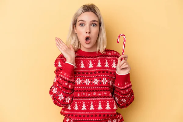 Mladá Běloška Žena Drží Vánoční Hůl Izolované Žlutém Pozadí Překvapené — Stock fotografie