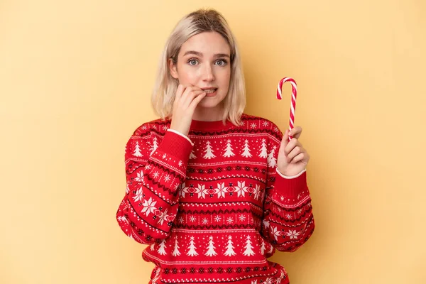 Giovane Donna Caucasica Possesso Bastone Natale Isolato Sfondo Giallo Mordere — Foto Stock