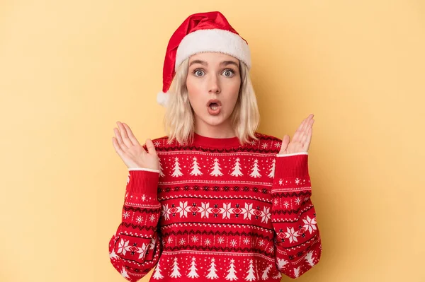 若いです白人女性を祝いますクリスマスは黄色の背景に孤立驚きとショックを受けました — ストック写真