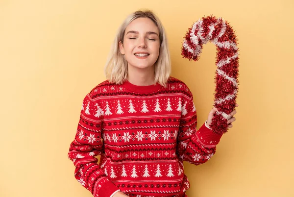 Mladá Běloška Žena Drží Velké Vánoční Hůl Izolované Žlutém Pozadí — Stock fotografie