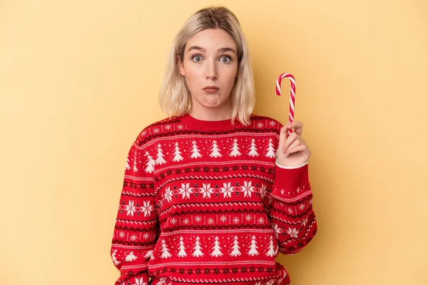 Jonge Blanke Vrouw Met Een Kerststokje Geïsoleerd Gele Achtergrond Schouders — Stockfoto