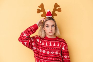 Sarı arka planda izole edilmiş ren geyiği şapkası takan beyaz bir kadın şok geçiriyordu, önemli bir buluşmayı hatırladı..