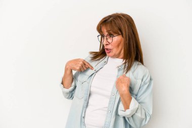 Beyaz arka planda izole edilmiş orta yaşlı beyaz kadın parmağını gösterip gülümseyerek şaşırdı..