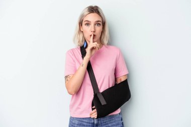 Kırık elli beyaz bir kadın mavi arka planda izole edilmiş ya sır saklıyor ya da sessizlik istiyor..