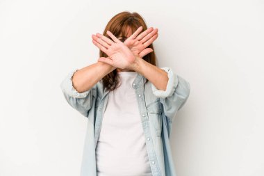 Beyaz arka planda izole edilmiş orta yaşlı beyaz kadın iki kolu çapraz tutuyor, inkar kavramı.