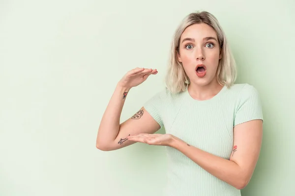 Mujer Caucásica Joven Aislada Sobre Fondo Verde Sorprendida Sorprendida Sosteniendo — Foto de Stock